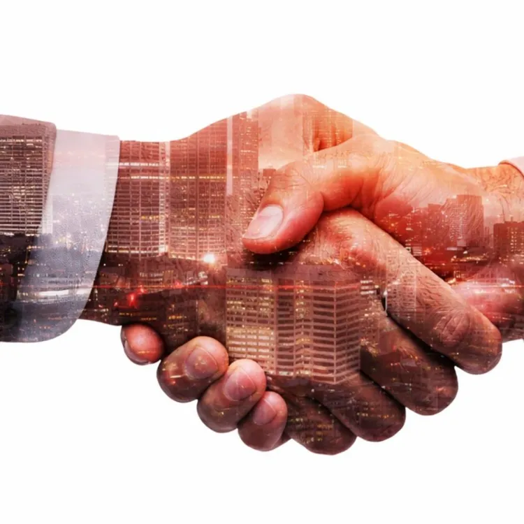 Two people shaking hands over a city skyline